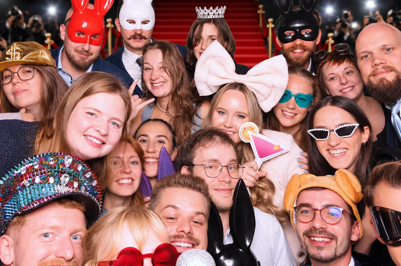 Rozjaření hosté při večerní svatební zábavě pózují s cedulemi Ještě jednu! ve fotokoutku